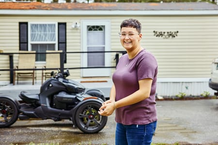 Woman in purple shirt with a motorcycle