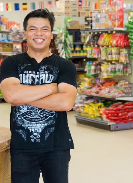 Mans with arms crossed in market